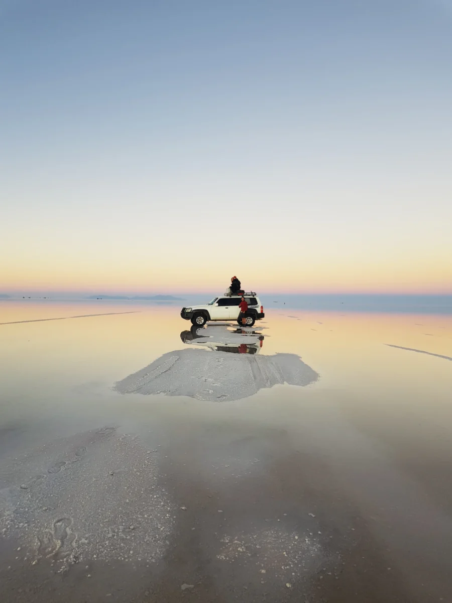 4x4 jeep on the mirror of the Salar de Uyuni at sunset