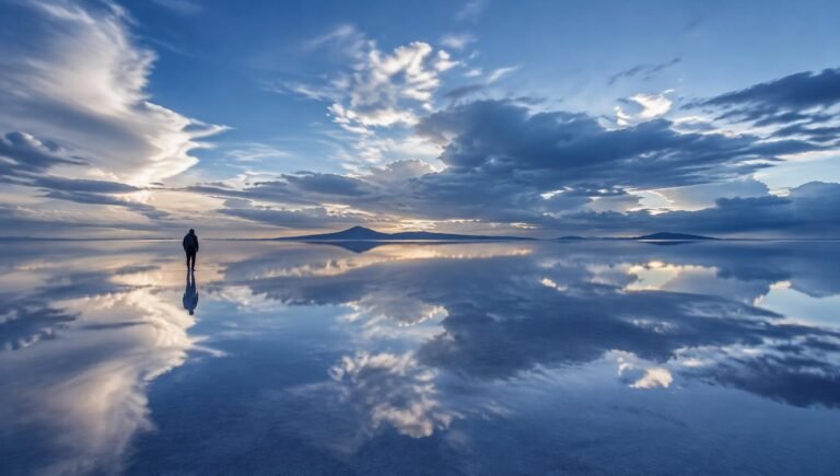 Salar de Uyuni reflecting a cloud-filled blue sky