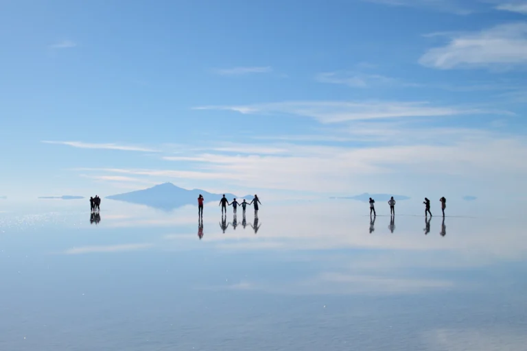 Travelers reflected on the wet Salar de Uyuni